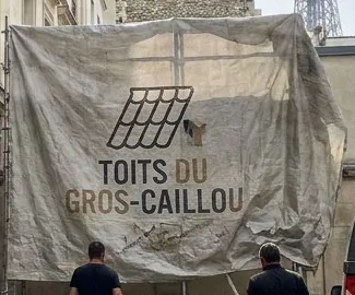 Bâche de chantier au nom des Toits du Gros-Caillou tendue sur un échafaudage à Paris 7e