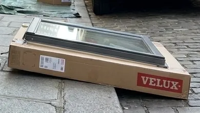 Fenêtre de toit Velux neuve livrée sur le trottoir avant la pose, couvreur à Paris 7e
